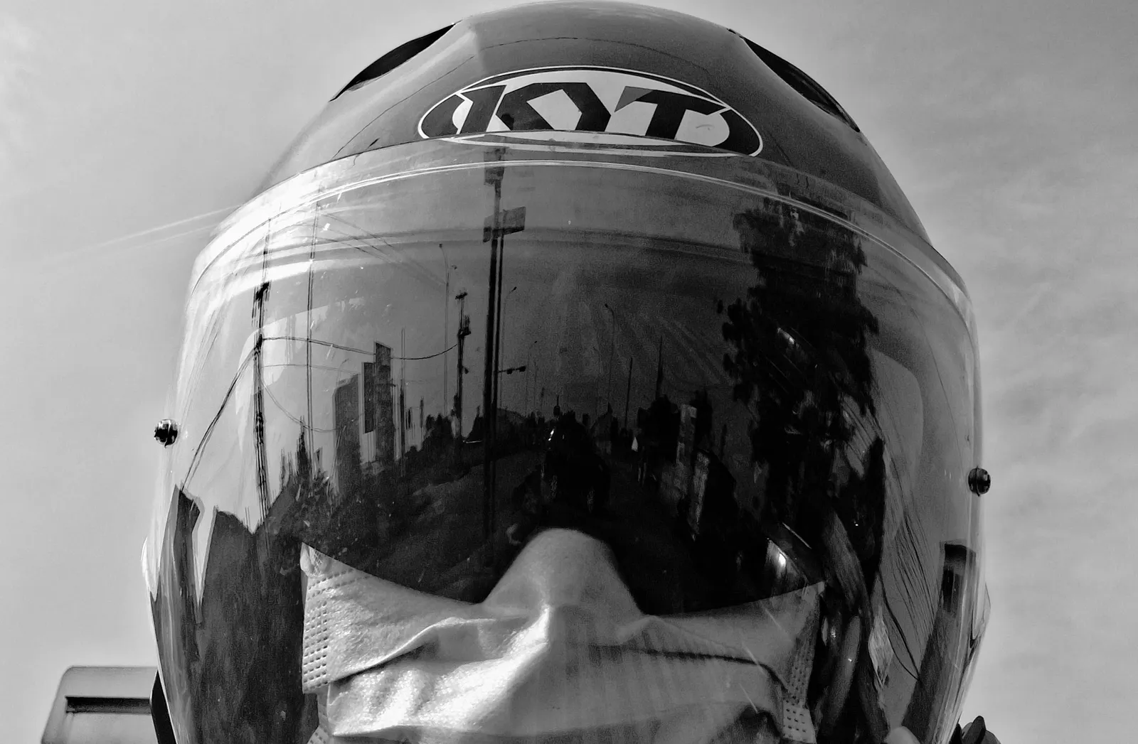 Black and white photo of a motorcycle helmet reflecting the street